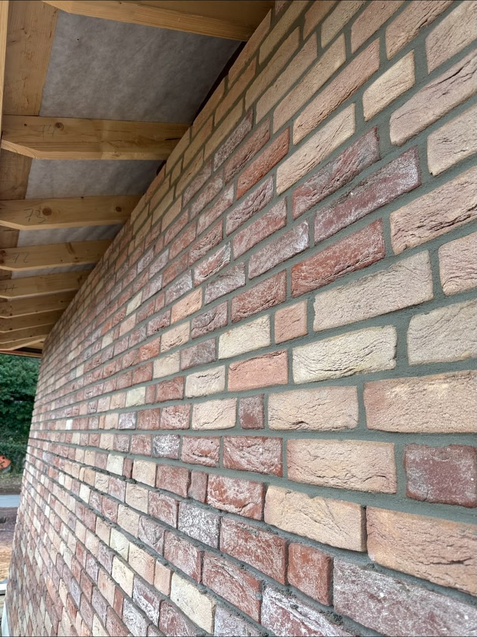 Neubau mit frisch verfugter Klinkerfassade und dunklem Fugenmörtel unter einem neuen Dachstuhl